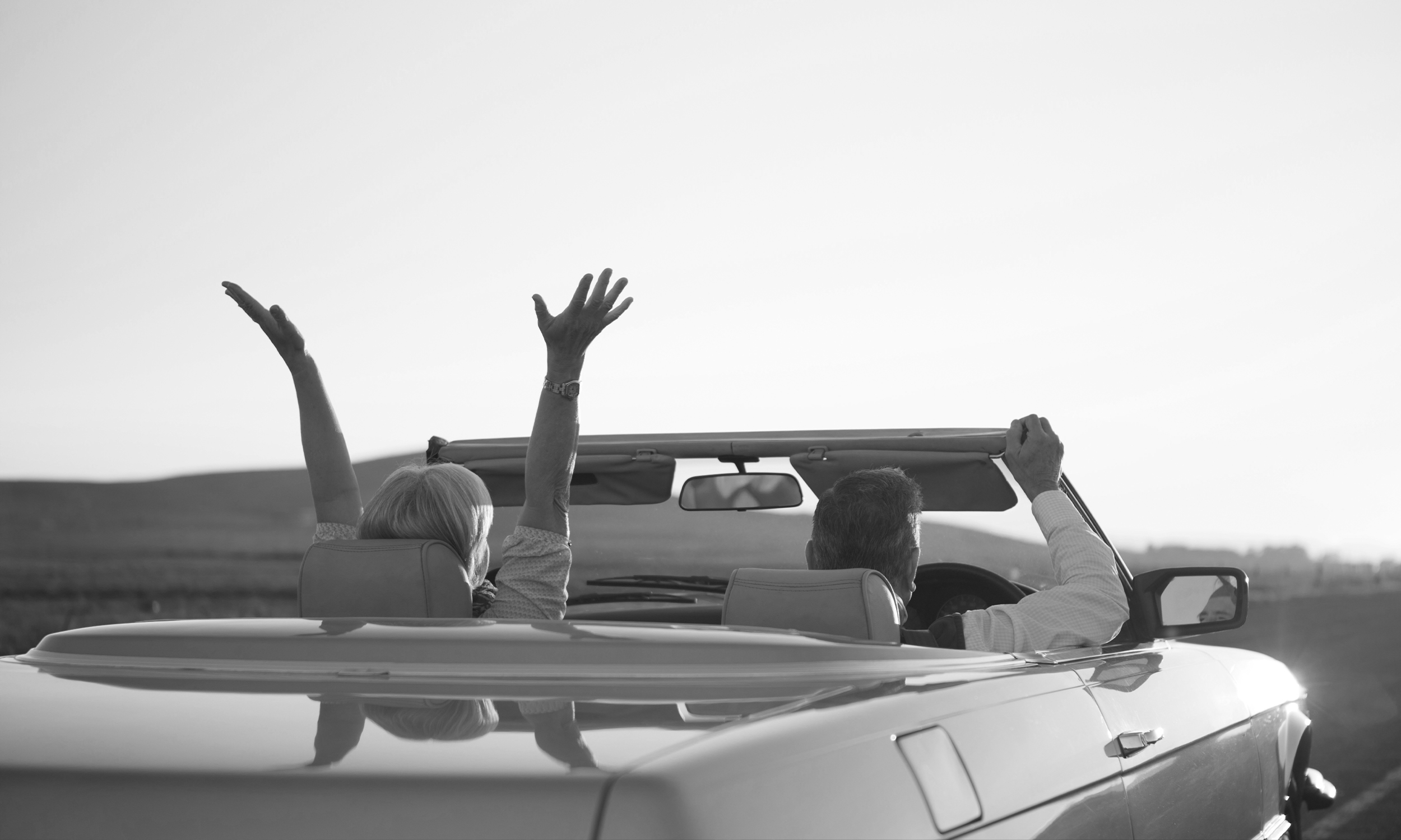 retired person in their car with their hands up